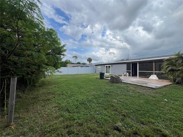 view of yard with a sunroom, a fire pit, and a patio area