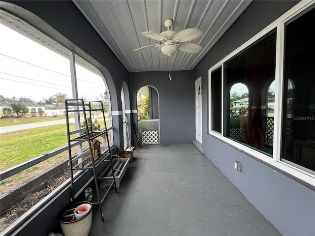 unfurnished sunroom with ceiling fan