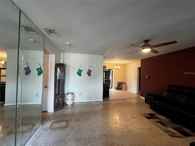 living room featuring ceiling fan with notable chandelier