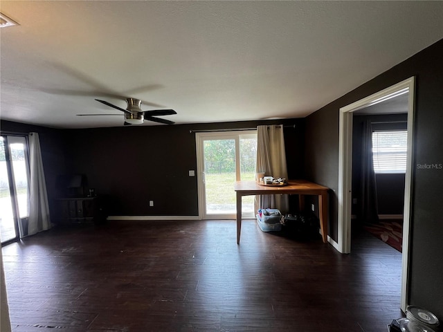 unfurnished living room featuring ceiling fan and dark hardwood / wood-style floors