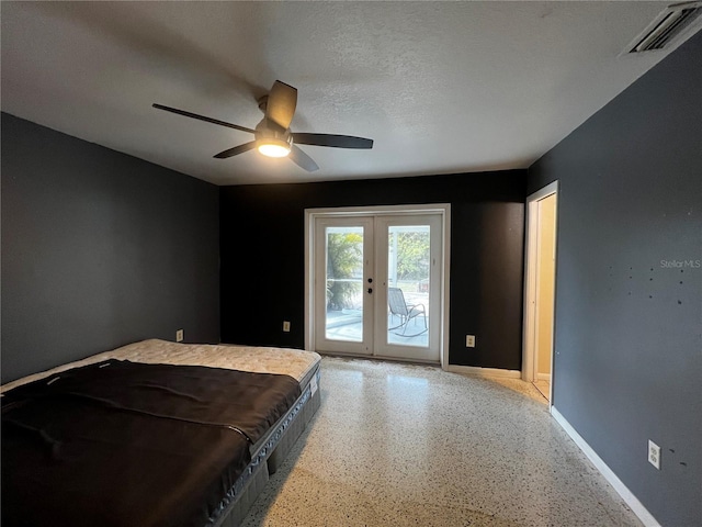 bedroom with ceiling fan, access to outside, a textured ceiling, and french doors