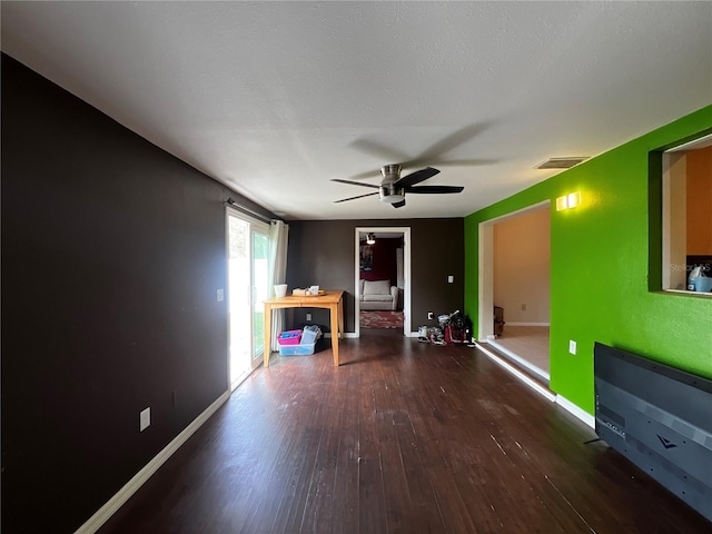 interior space featuring dark wood-type flooring and ceiling fan