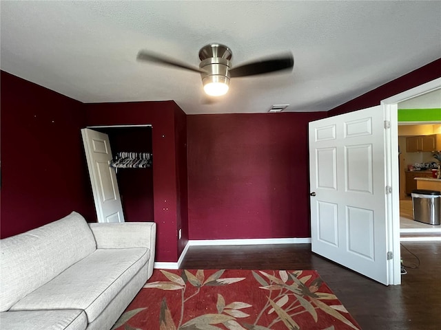 interior space with ceiling fan, a textured ceiling, and dark hardwood / wood-style flooring