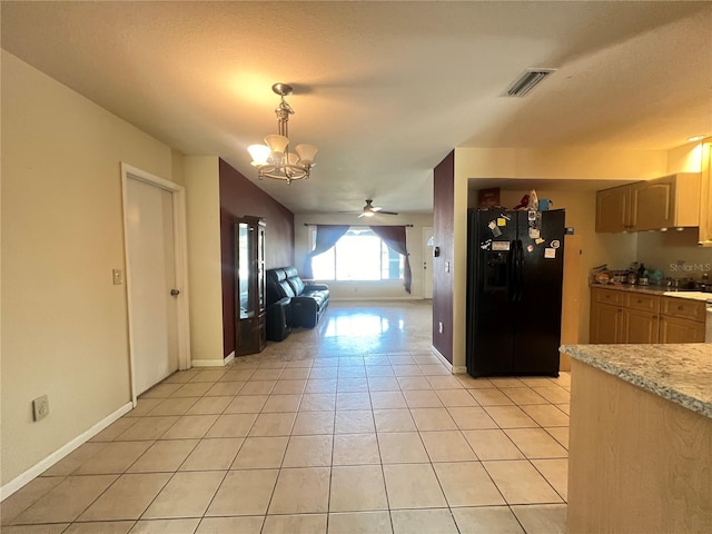 1405 Dorchester St, Port Charlotte, FL 33952 - kitchen with black fridge, light countertops, a chandelier, ceiling fan, and light tile patterned floors