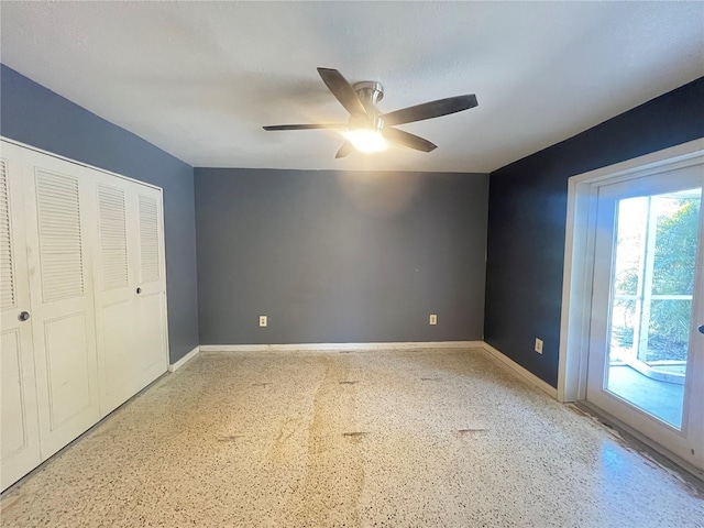 1405 Dorchester St, Port Charlotte, FL 33952 - unfurnished bedroom featuring dark speckled floor, access to outside, baseboards, a ceiling fan, and a closet