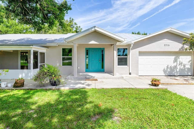 single story home featuring covered porch, a garage, and a front lawn