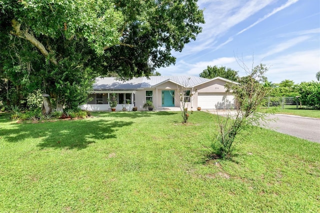 single story home featuring a garage, a front yard, and driveway