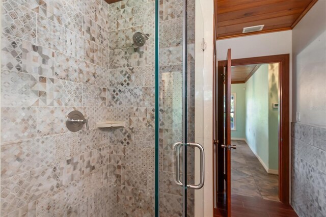 bathroom with an enclosed shower, wooden ceiling, tile walls, ornamental molding, and hardwood / wood-style flooring