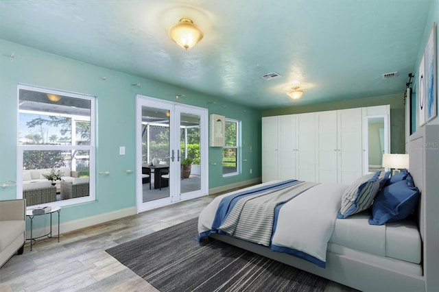 bedroom featuring a closet, access to outside, french doors, and light hardwood / wood-style floors