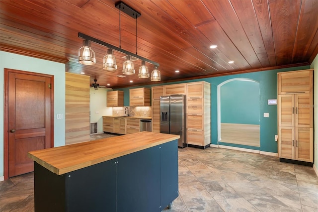 kitchen with hanging light fixtures, wooden counters, appliances with stainless steel finishes, and light brown cabinetry