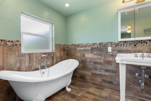 bathroom featuring a soaking tub, visible vents, tile walls, and a wainscoted wall