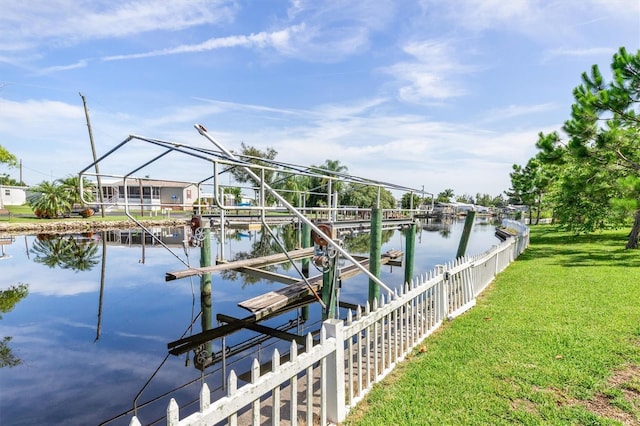 view of dock featuring a water view, a yard, and boat lift