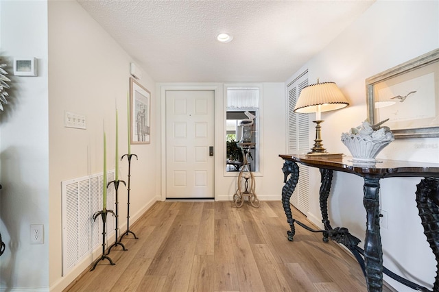 foyer featuring a textured ceiling and light hardwood / wood-style flooring