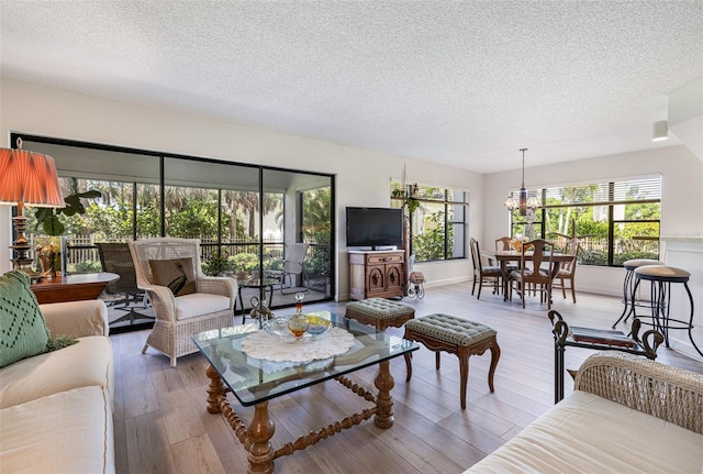 living room with an inviting chandelier, dark hardwood / wood-style flooring, and a textured ceiling