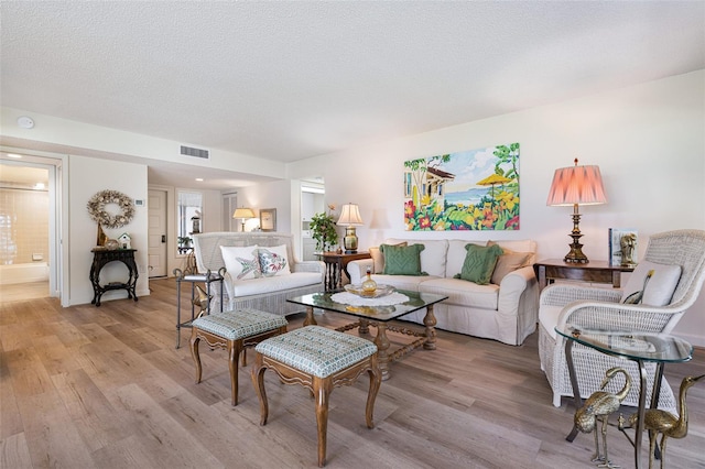 living room with a textured ceiling and light hardwood / wood-style floors