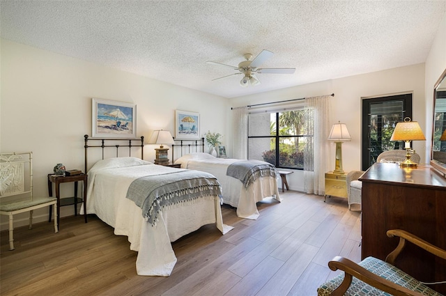 bedroom featuring a textured ceiling, ceiling fan, and dark hardwood / wood-style floors