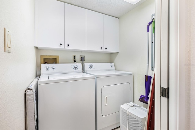 clothes washing area featuring a textured ceiling, cabinets, and independent washer and dryer