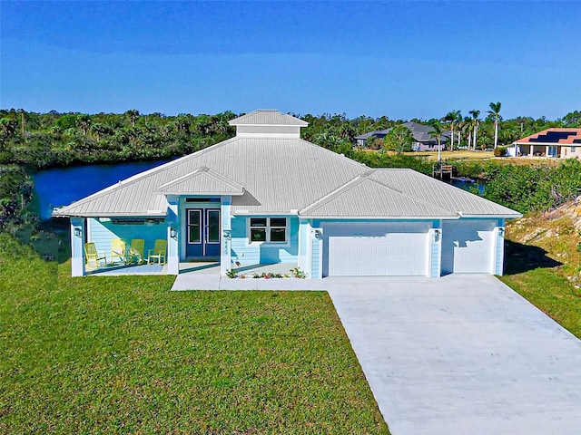 view of front facade featuring a garage, a water view, and a front yard