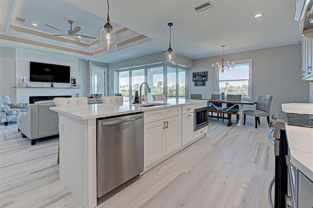 kitchen featuring sink, white cabinetry, a kitchen island with sink, hanging light fixtures, and stainless steel appliances