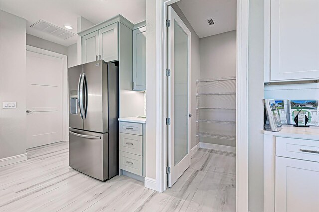 kitchen with stainless steel refrigerator with ice dispenser and light wood-type flooring