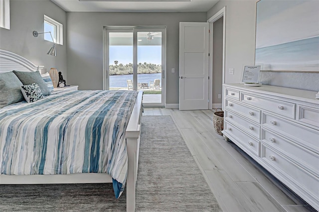 bedroom featuring a water view and access to exterior