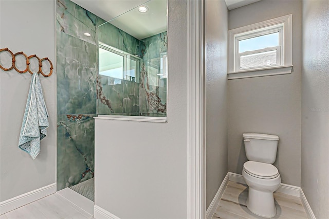 bathroom with toilet and a tile shower