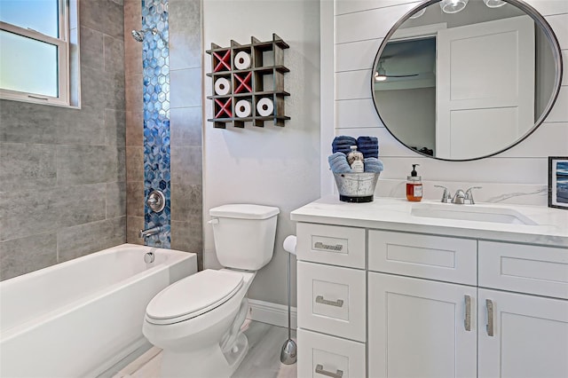 full bathroom with vanity, tiled shower / bath combo, and toilet