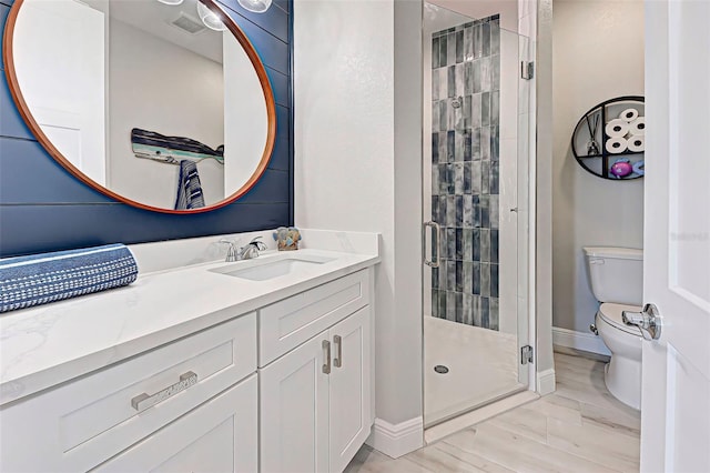 bathroom featuring walk in shower, vanity, and toilet