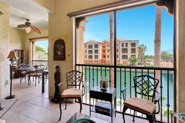 balcony featuring ceiling fan and a water view