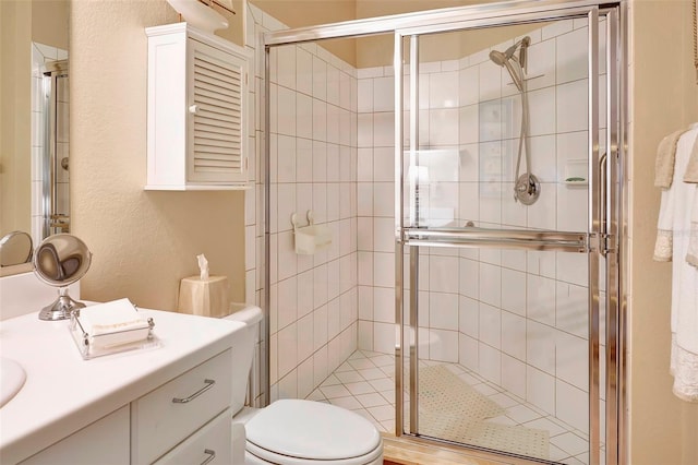 bathroom featuring toilet, an enclosed shower, and vanity