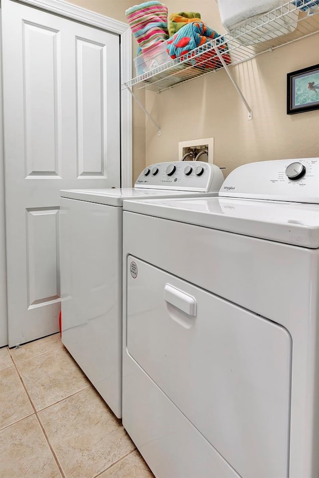 washroom with washer and dryer and light tile patterned flooring