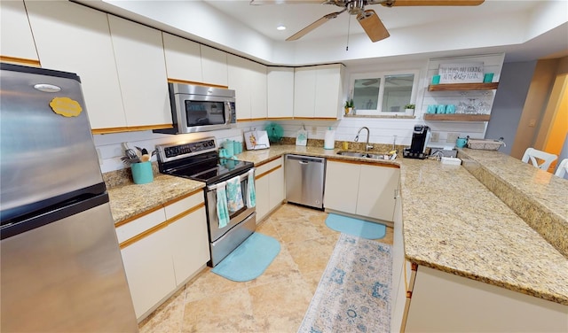 kitchen featuring sink, appliances with stainless steel finishes, backsplash, and white cabinetry