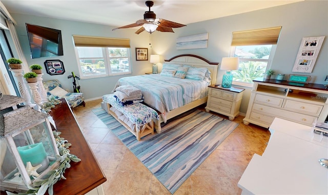 tiled bedroom featuring multiple windows and ceiling fan