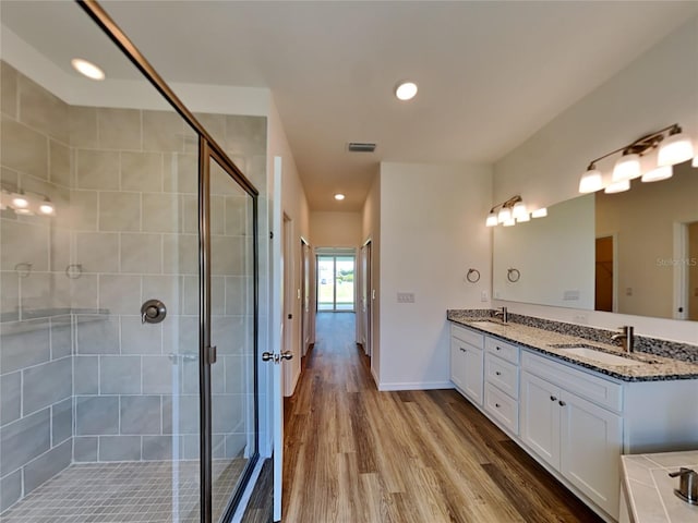 bathroom featuring vanity, hardwood / wood-style flooring, and walk in shower