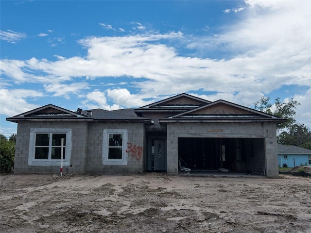 property under construction featuring concrete block siding and a garage