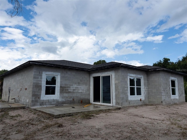 back of house with a patio area and concrete block siding