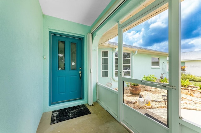 doorway to outside featuring unfinished concrete flooring