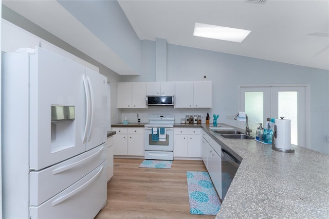 kitchen with tasteful backsplash, lofted ceiling, stainless steel appliances, white cabinetry, and a sink