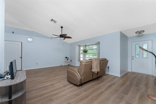 living room featuring ceiling fan, lofted ceiling, and light hardwood / wood-style floors