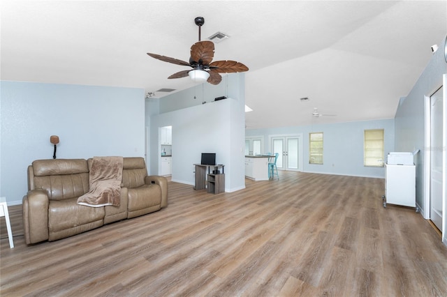 living area with ceiling fan, wood finished floors, lofted ceiling, and visible vents