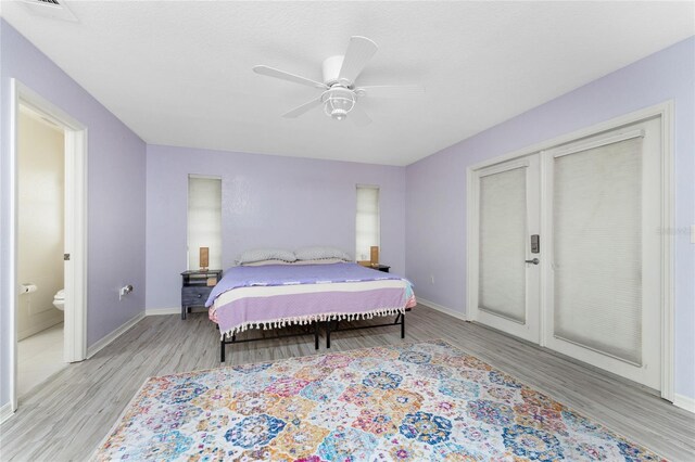 bedroom with connected bathroom, light hardwood / wood-style flooring, and ceiling fan