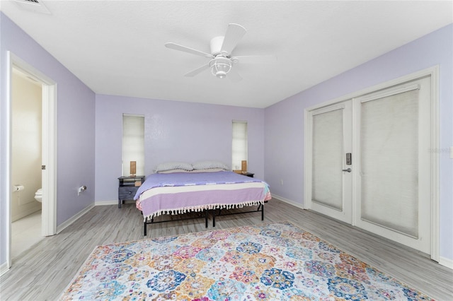 bedroom featuring a ceiling fan, visible vents, light wood-style flooring, and baseboards