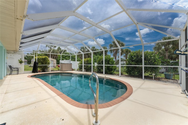 view of swimming pool featuring a patio, a lanai, and a shed