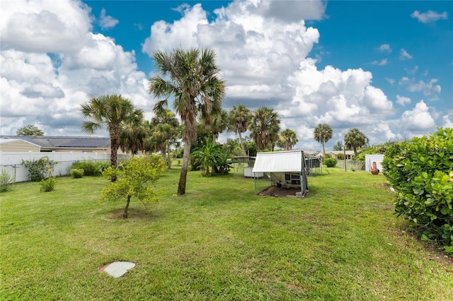 view of yard with an outdoor structure, fence, and exterior structure