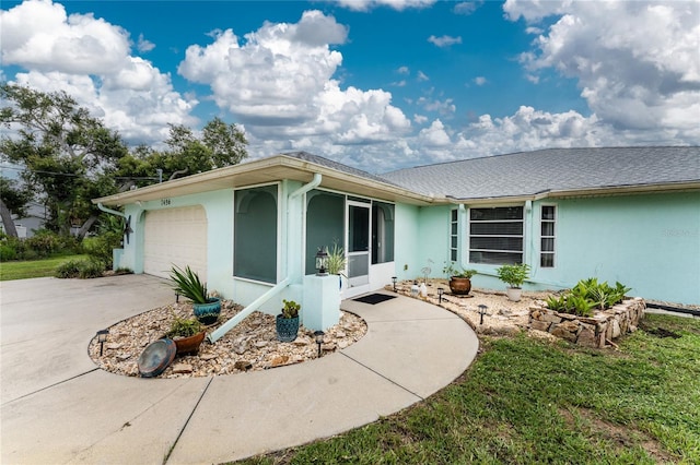 view of property exterior with stucco siding, an attached garage, and driveway