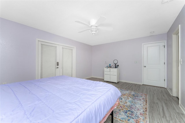 bedroom featuring baseboards, ceiling fan, and light wood-style floors