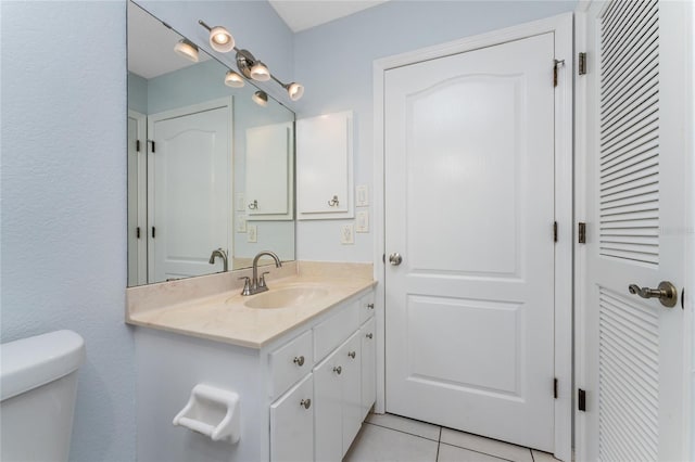 bathroom featuring vanity, tile patterned floors, and toilet