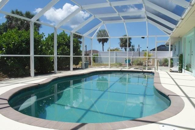 view of pool with a fenced in pool, glass enclosure, and a patio area