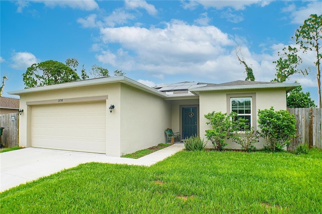 ranch-style home with a garage, solar panels, and a front yard