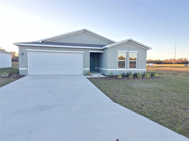 ranch-style home featuring a garage and a lawn